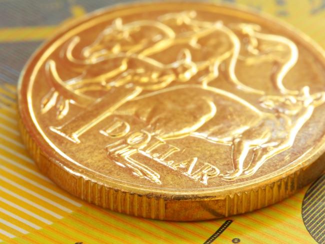 Australian one dollar coin on a fifty dollar note.  Close-up view, with shallow depth of field; generic money