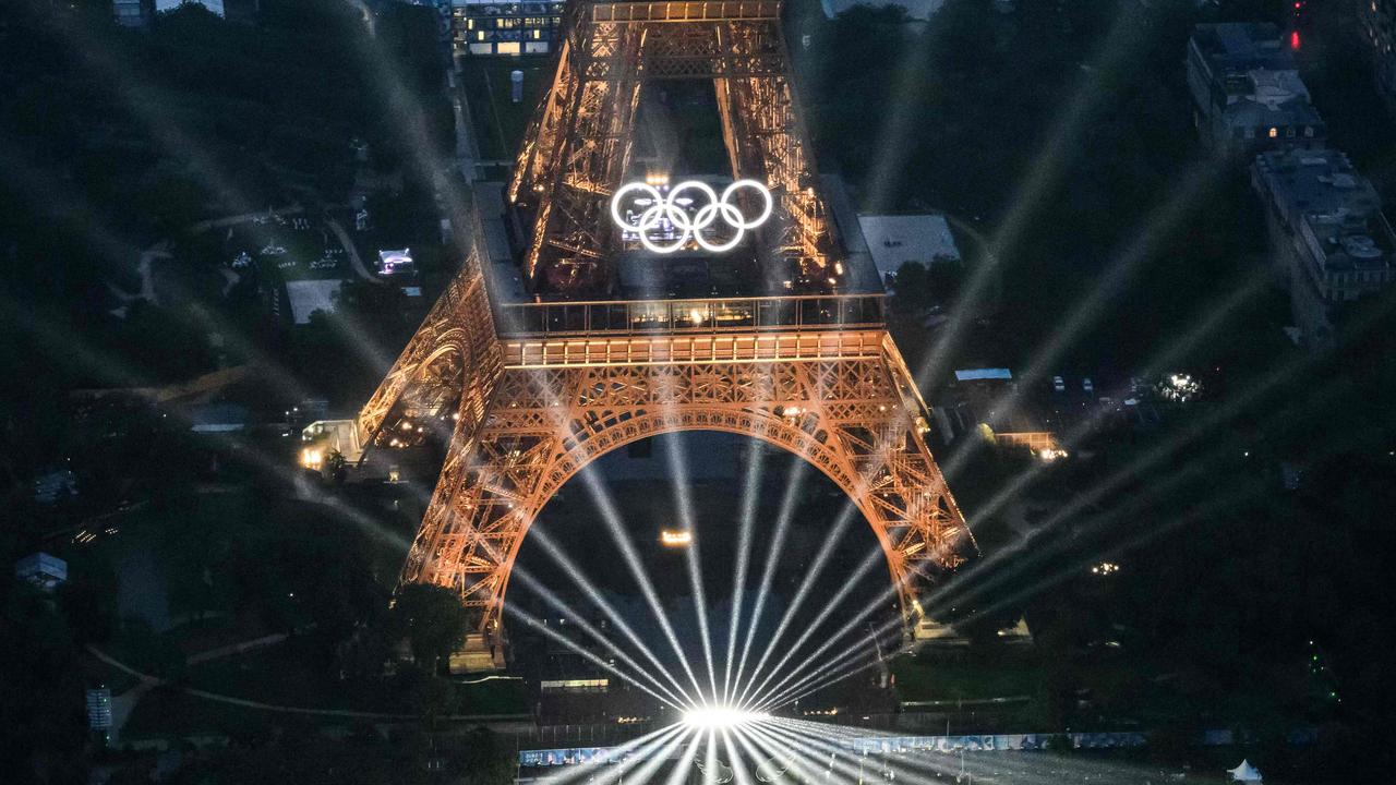 TOPSHOT - A photograph taken from an helicopter on July 26, 2024 shows an aerial view of the Eiffel Tower and the Olympics Rings lightened up during the opening ceremony of the Paris 2024 Olympic Games in Paris. (Photo by Lionel BONAVENTURE / POOL / AFP)