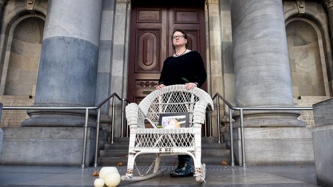 Katherine Ammear, the organiser of an online vigil for Ann Marie Smith, with a woven cane chair on the steps of Parliament House. Ms Smith spent the last year of her life in a cane chair. Picture: Naomi Jellicoe