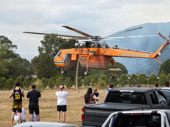 Locals watch on as water bombers attempt to wrangle the blaze. Picture: Jason Edwards