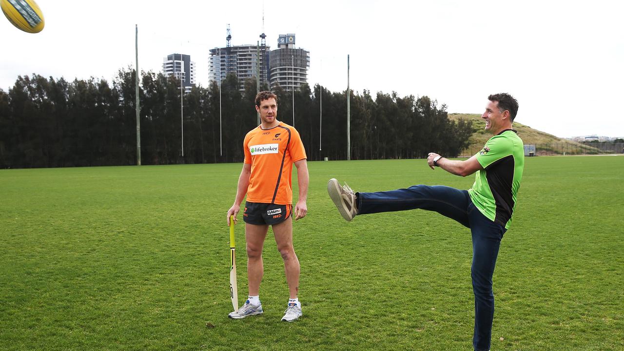 Mike Hussey has a kick of the footy with ex-Giant Shane Mumford during a promotion for the Sydney Thunder BBL team. Picture: Phil Hillyard