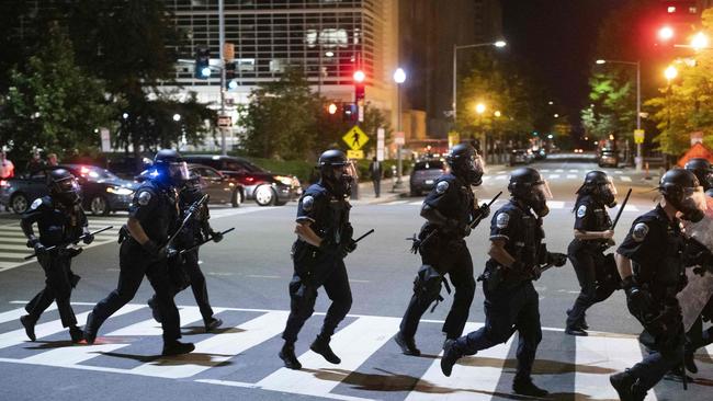 Police run across a street during a demonstration near the White House.