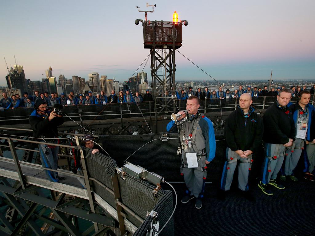 A dawn service was held on the summit of the Sydney Harbour Bridge to commemorate ANZAC Day. Bugler and Leading seaman Marcus Salone plays The Last Post on top of the bridge with NRL CEO Todd Greenberg watching on. Picture: Toby Zerna