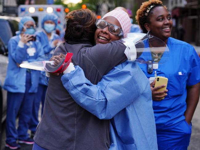 Medical workers from Lenox Hill Hospital in New York hug while people show gratitude as part of the nightly #ClapBecauseWeCare. Picture: Getty Images