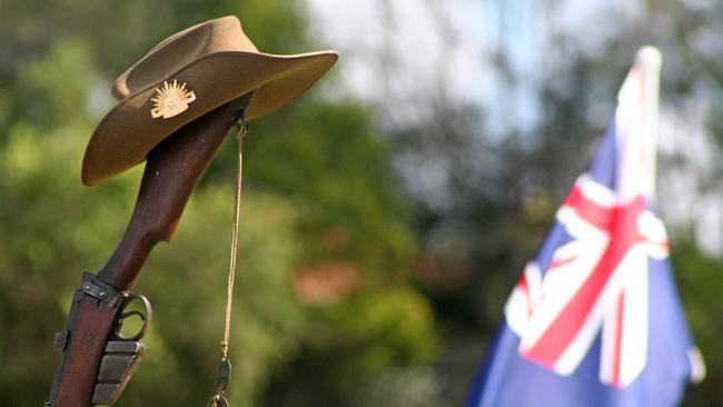 An Australia Army slouch hat and dogtags hang upon a vintage 303 rifle.