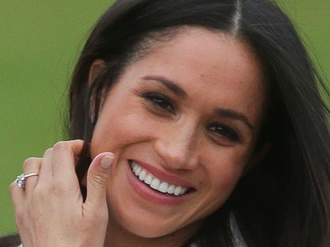 US actress Meghan Markle shows off her engagement ring she poses with her fiancée Britain's Prince Harry in the Sunken Garden at Kensington Palace in west London on November 27, 2017, following the announcement of their engagement. Britain's Prince Harry will marry his US actress girlfriend Meghan Markle early next year after the couple became engaged earlier this month, Clarence House announced on Monday. / AFP PHOTO / Daniel LEAL-OLIVAS