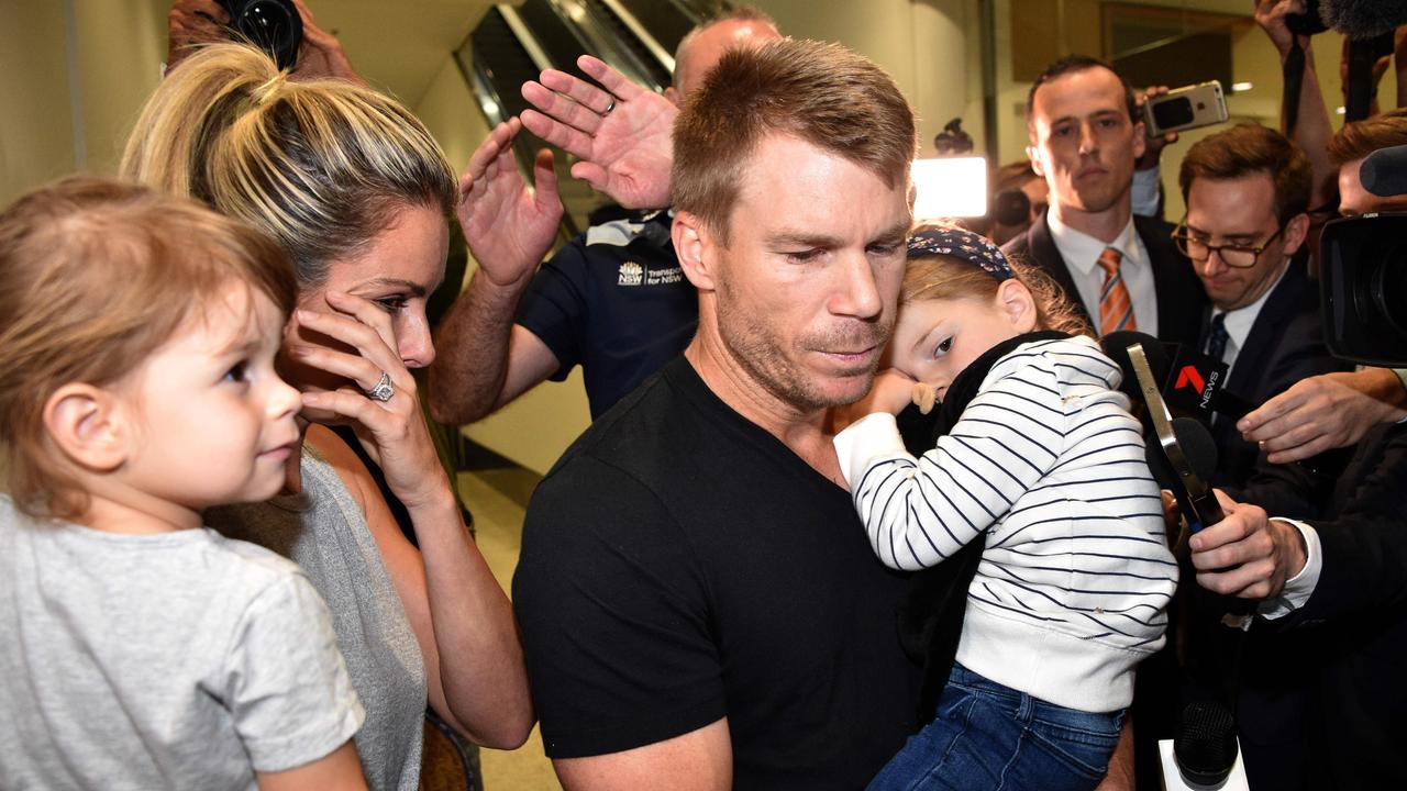 Australian cricketer David Warner, his wife Candice and their daughters leave the airport after arriving back in Sydney. Picture: AFP PHOTO / PETER PARKS