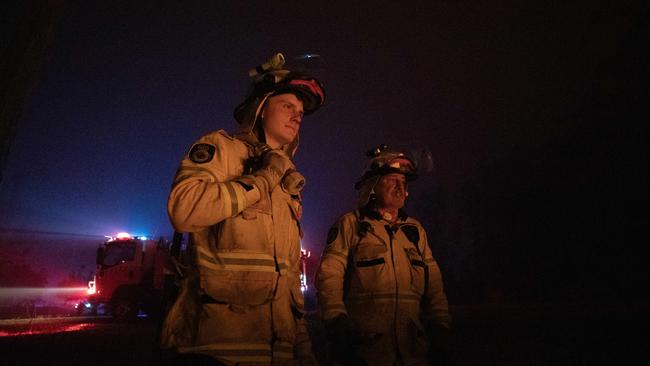 Hayden Hogno and Raymond Daly watch the bushfire on the NSW south coast early Wednesday morning. Picture: Liam Mendes / The Australian