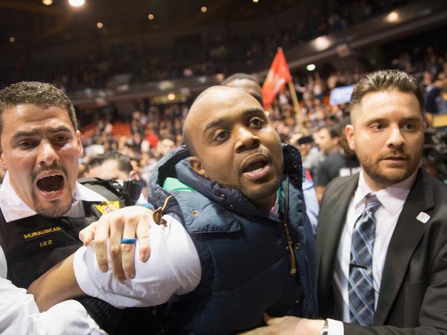 An activist is removed by police after it was announced that the Chicago rally was cancelled.