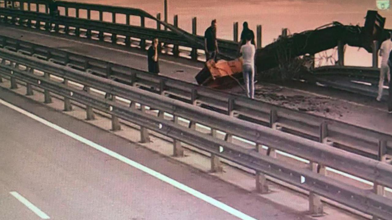 Image allegedly shows people inspecting damage to the Kerch Bridge. (Photo by Handout / UKRAINIAN SECURITY SERVICE / AFP)