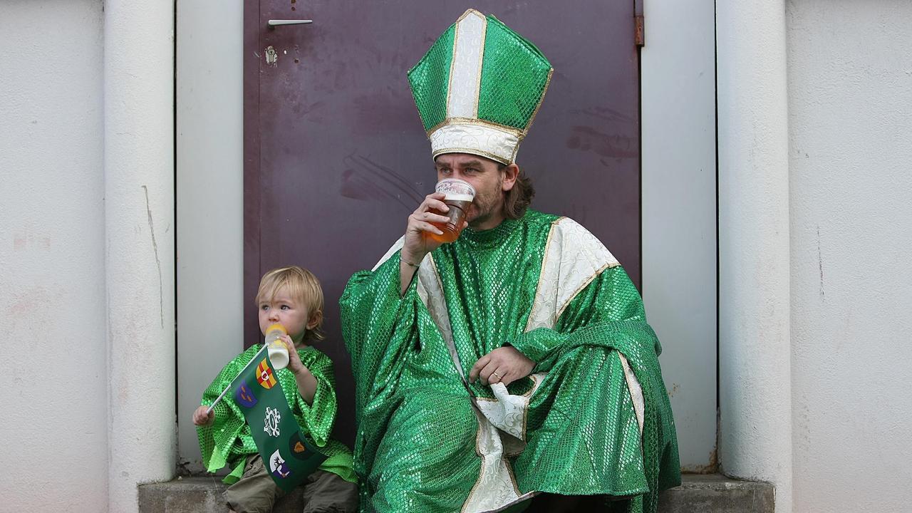 An Ireland fan and his daughter enjoy a beer and a bottle of milk respectively.