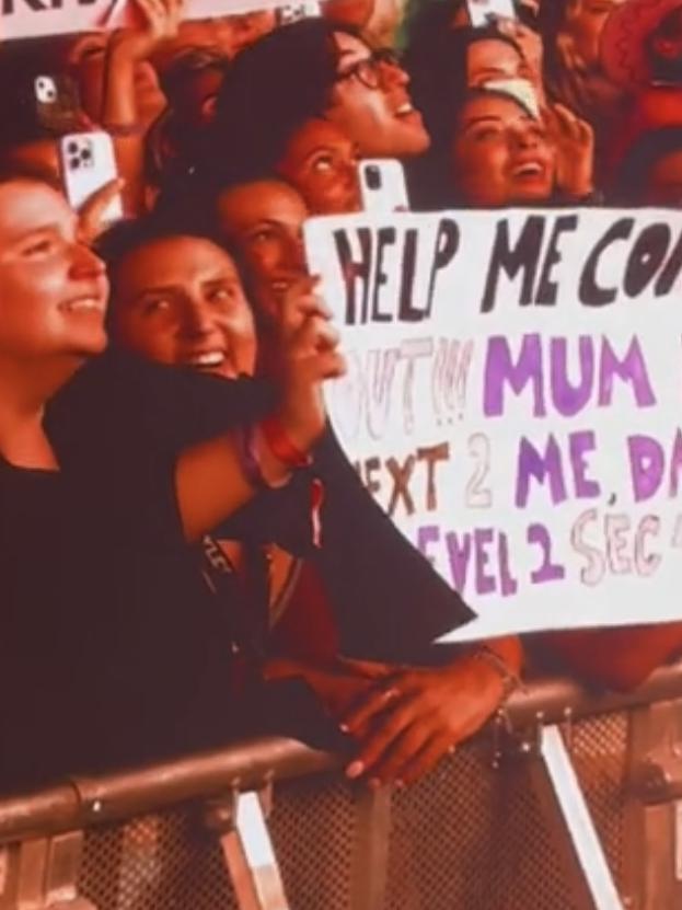 Fauve holding a “coming out” sign with her mum next to her.