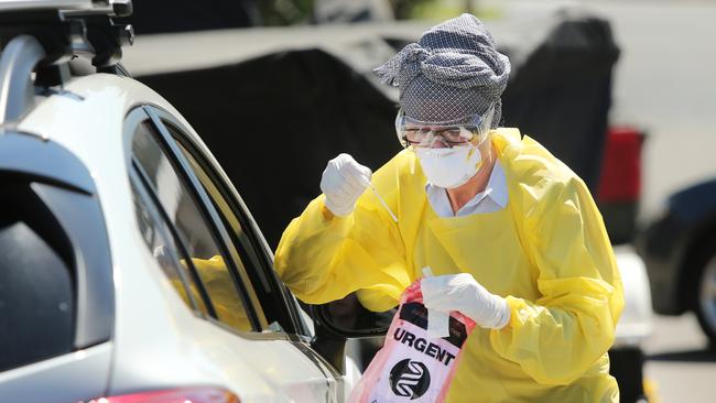 Pictured is a doctor conducting drive up COVID-19 tests. Picture: Richard Dobson