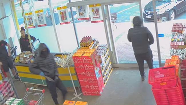 Abdirahman Basa, 19, (L) and his co-accused threatened workers with a machete as they stole cash and bottles of vodka from NQR supermarket in Werribee on March 28. Picture: Supplied.