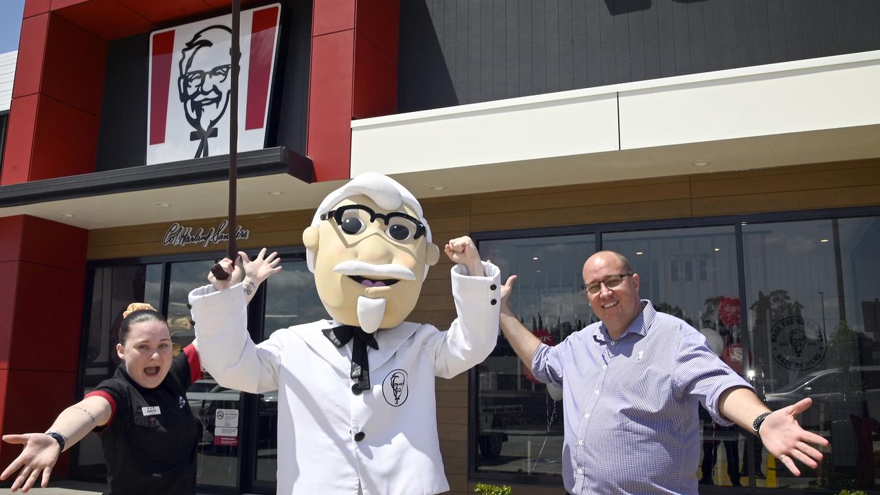 KFC opens in Highfields. KFC mascot, Colonel Sanders, with store manager Amber Harding-Dolan and area manager Trent Brigginshaw.