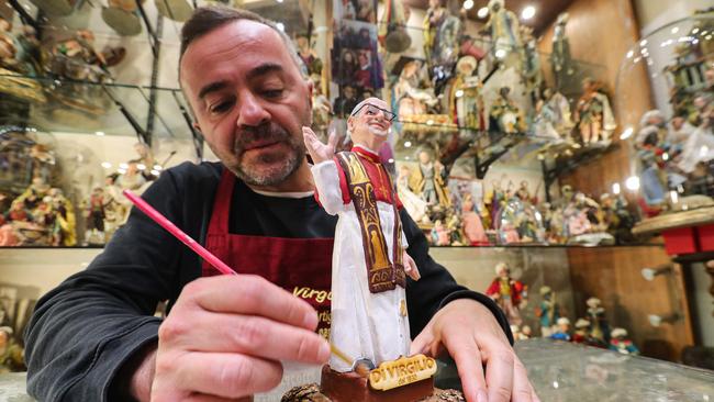 Craftsman Gennaro Di Virgili paints the finishing touches of a statue of newly elected Pope Leo XIV at his shop in Naples. Picture: AFP