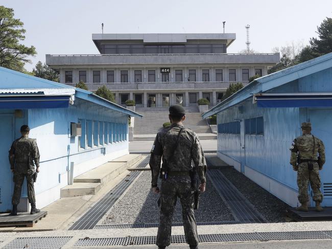 FILE - In this April 18, 2018 file photo, two South Korean soldiers, center and left, and U.S. soldier, right, stand in the southern side during a press tour at the border village of Panmunjom in the Demilitarized Zone, South Korea. North and South Korea and the U.S.-led United Nations Command on Tuesday, Oct. 16, 2018, are meeting to discuss efforts to disarm a military zone the rivals control within their shared border under a peace agreement between the Koreas. (AP Photo/Lee Jin-man, File)