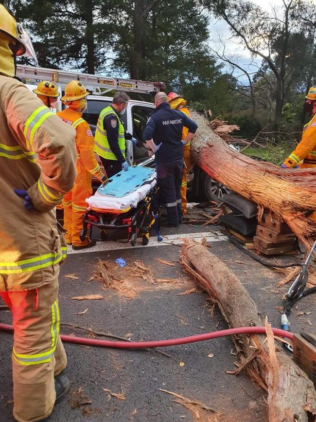 Paramedics and CFA work to get a 29-year-old Diamond Creek man out of the car. Picture: Lilydale SES