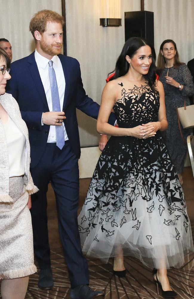 Prince Harry gently touches his pregnant wife Meghan as they make their way to their table. Picture: Dylan Robinson