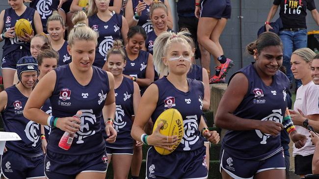 Coolangatta's Paige Parker (left) Courtney Ugle (centre) and Kitara Whap-Farrar (right) lead their team out for their Indigenous Round clash against Wilston Grange. Picture: David Layden