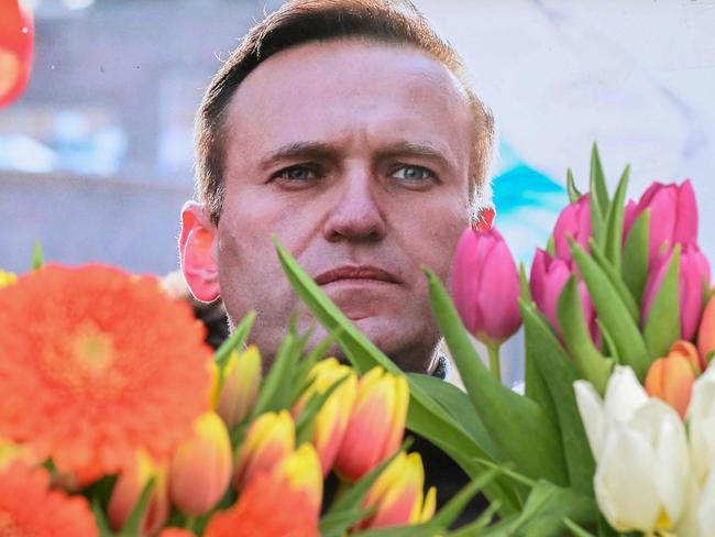 Flowers are seen placed around portraits of late Russian opposition leader Alexei Navalny, who died in a Russian Arctic prison, at a makeshift memorial in front of the former Russian consulate in Frankfurt am Main, western Germany, on February 20, 2024. Navalny's widow Yulia Navalnaya accused Russian President Putin of killing her husband and vowed to continue Navalny's work. (Photo by AFP)