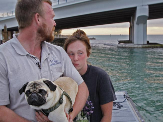 Tanner Broadwell holds his dog with Nikki Walsh at Madeira Beach, Fla., on Wednesday, Feb. 7, 2018.  The couple who abandoned their workaday lives to buy a sailboat for a once-in-a-lifetime adventure instead lost almost everything when it sank on day two of their journey off Florida. They escaped injury when the 28-foot boat hit something and capsized Wednesday in the Gulf of Mexico near Madeira Beach. (Jim Damaske/Tampa Bay Times via AP)