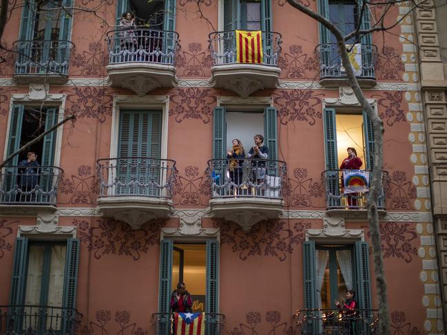 People applaud from their houses in support of the medical staff that are working on the COVID-19 virus outbreak in Barcelona, Spain. Picture: AP