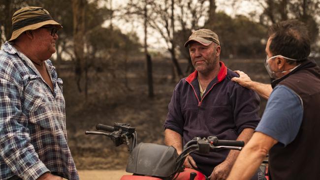 Steve Shipton (centre) is consoled by fellow farmers Bernie Smith (left) and Peter Mercieca in Coolagolite, NSW. Picture: Sean Davey/AAP.