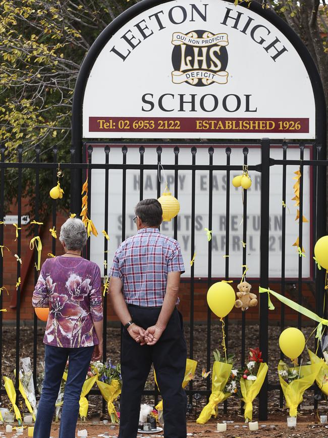 Merrilyn and Robert Scott, parents of slain Leeton teacher Stephanie Scott, revisit the memorial on the fence line of Leeton High School. Photo: Chris McKeen