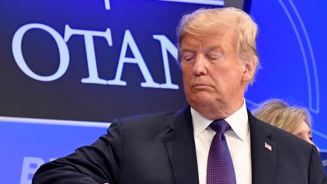 U.S. President Donald Trump checks time prior to a dinner of leaders at the Art and History Museum at the Park Cinquantenaire in Brussels on July 11, 2018. NATO leaders gathered in Brussels on July 11 for a two-day summit to discuss Russia, Iraq and their mission in Afghanistan. / AFP PHOTO / POOL / Geert Vanden Wijngaert