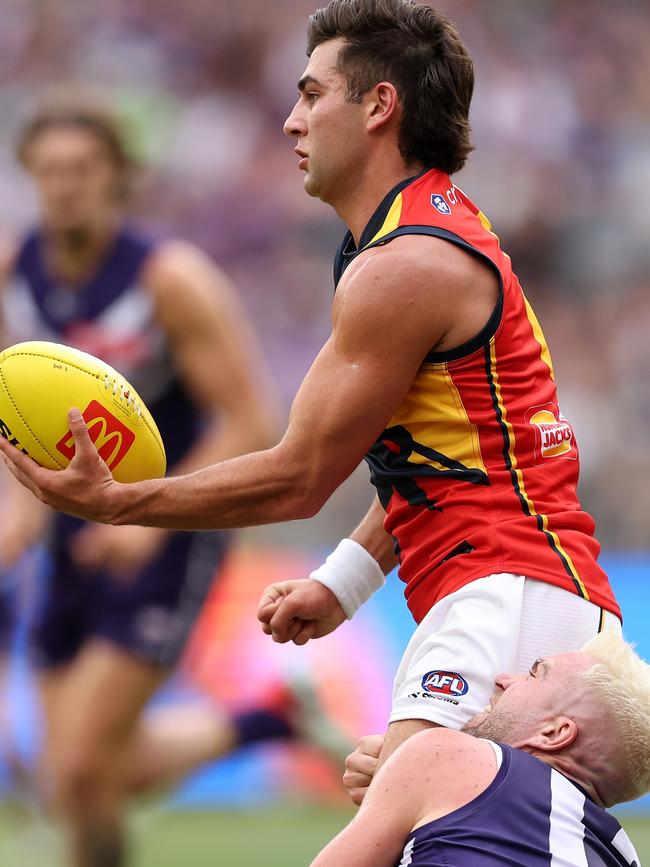 Adelaide’s Josh Rachele handballs under pressure from Docker Luke Ryan at Optus Oval on Good Friday. Picture: Paul Kane/Getty Images