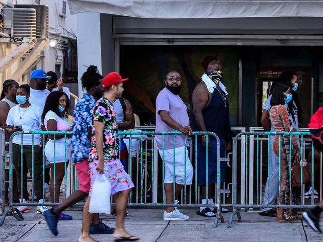 People stand in queue to enter a restaurant on Ocean Drive in Miami Beach. Picture: AFP