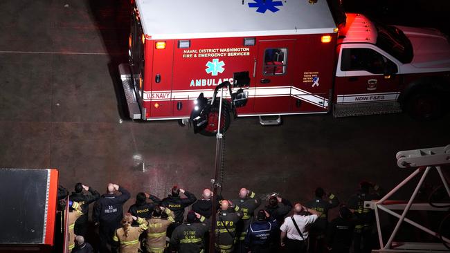 Local first responders salute the flag draped bodies of service members killed in the aviation crash. Picture: Andrew Harnik/Getty Images/AFP