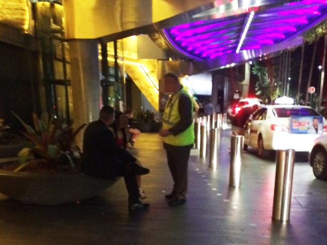 A security guard has words with a man who has been screaming at his female companion.