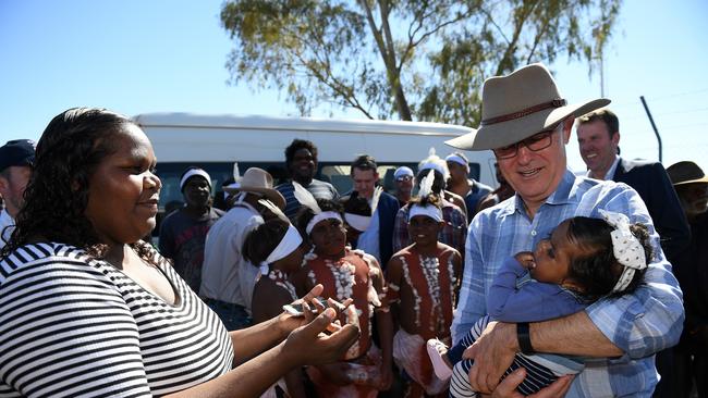 Prime Minister Malcolm Turnbull holds a young child as he arrives at Tennant Creek   on Sunday. Picture: AAP Image/Dan Himbrechts