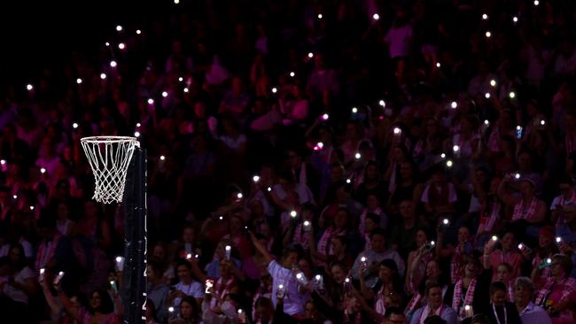 Fans hold torches as a power cut affects parts of the stadium in Adelaide