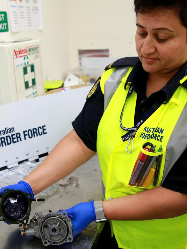 An Australian Border Force officer checks a package for illegal substances. Picture: Damian Shaw