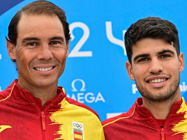 TOPSHOT - Spain's Rafael Nadal (L) and Spain's Carlos Alcaraz pose for pictures during a press conference at the Olympic Village, in Paris, on July 24, 2024, prior to take part in the men's singles tennis competition of the Paris 2024 Olympic Games. (Photo by MARTIN BERNETTI / AFP)