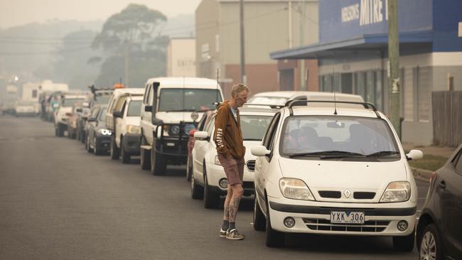 Ian Johnston from Melbourne waits in line for fuel at the Bermagui Shell service station. Picture: Sean Davey.