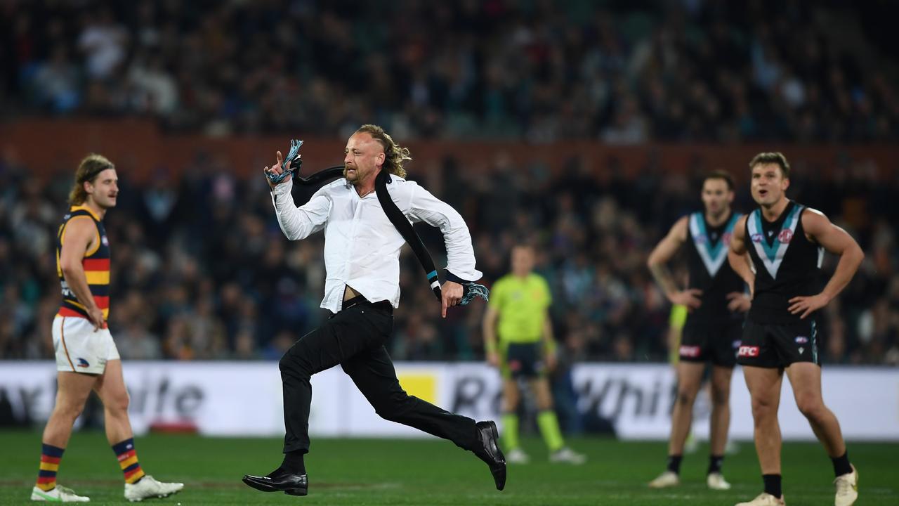 Pitch invader Jeremy Cortvriend dashes across Adelaide Oval during the round 23 Showdown on August 20, 2022. Picture: Mark Brake/Getty Images