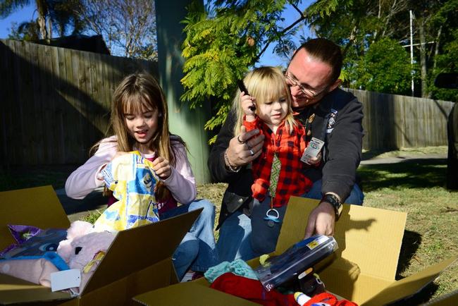 SMILING AGAIN: Tahlia Acai, 8, Xander Hill, 2, and Norman Hill had mixed emotions as they received gifts after losing all their possessions. Picture: David Nielsen