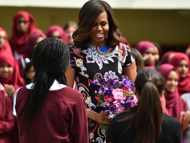 Rock star reception. Michelle Obama is greeted by two young girls at Mulberry School for Girls — which has an excellent record of education despite being in a disadvantaged area. Picture: Jeff J Mitchell / Getty Images.