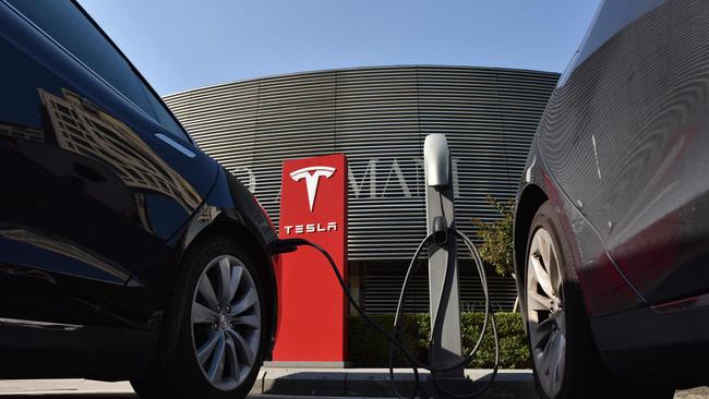 Tesla electric cars charge at a Tesla charging station outside a shopping mall in Beijing. Picture: AFP PHOTO / GREG BAKER