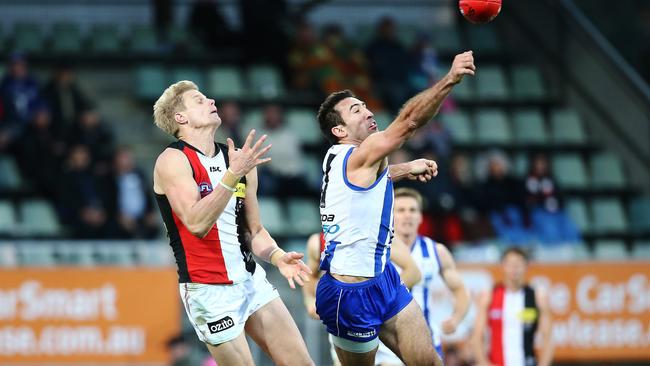 Michael Firrito punches the ball away from Nick Riewoldt. Picture: Luke Bowden