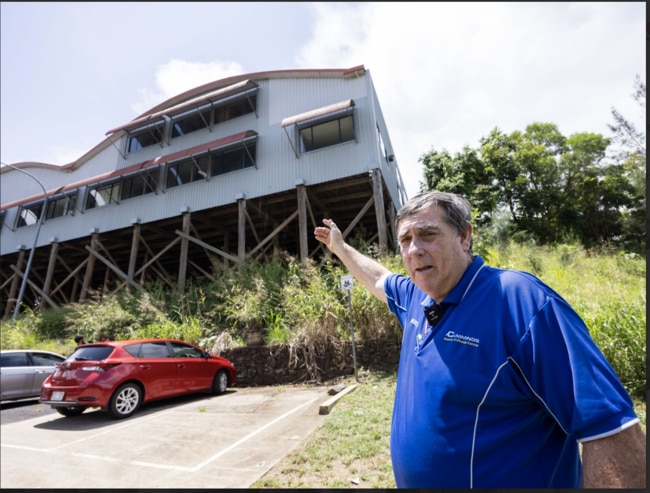 Cummings points to his shop on a levee, where flood water raised to the very top window. Picture: Media Mode/news.com.au