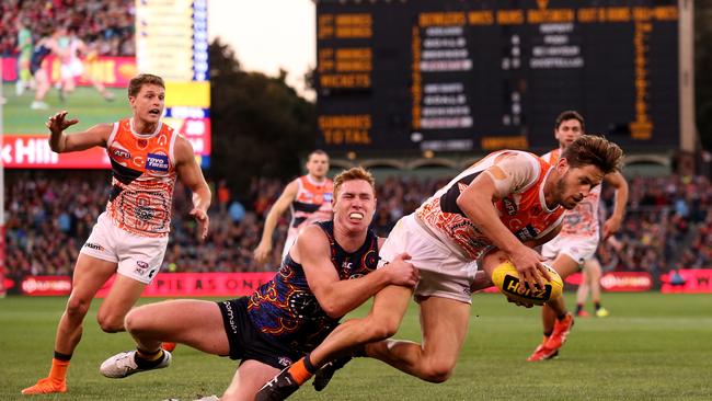 Tom Lynch hits the deck hard while tackling Callan Ward of the Giants. Picture: James Elsby/AFL Media/Getty Images