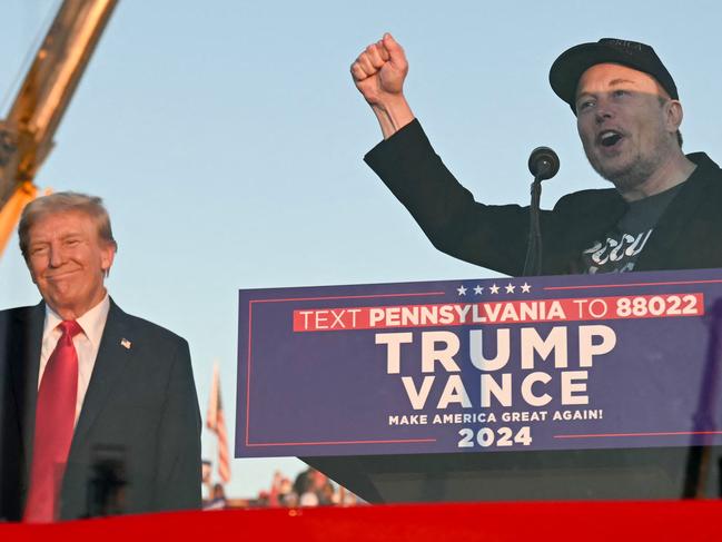 (FILES) Tesla CEO Elon Musk (R) speaks on stage as he joins former US President and Republican presidential candidate Donald Trump during a campaign rally at site of his first assassination attempt in Butler, Pennsylvania on October 5, 2024. Billionaire Elon Musk was expected in court in Philadelphia on October 31, 2024, after a judge ordered him to attend a hearing in a lawsuit seeking to halt his $1 million giveaways to registered US voters in swing states. (Photo by Jim WATSON / AFP)