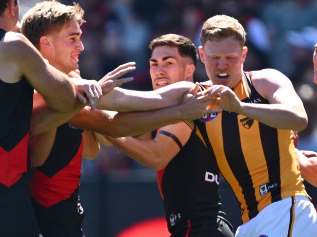 MELBOURNE, AUSTRALIA - MARCH 16: Bombers players remonstrate with James Sicily of the Hawks after he gave away a free kick to Andrew McGrath of the Bombers during the round one AFL match between Essendon Bombers and Hawthorn Hawks at Melbourne Cricket Ground, on March 16, 2024, in Melbourne, Australia. (Photo by Quinn Rooney/Getty Images)