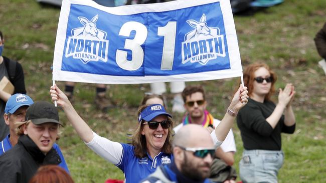 A North Melbourne supporter cheers on the Roos earlier this season.