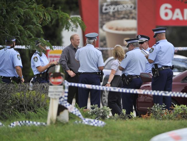 Detective and police discuss events inside the cordoned-off area outside Hungry Jacks.